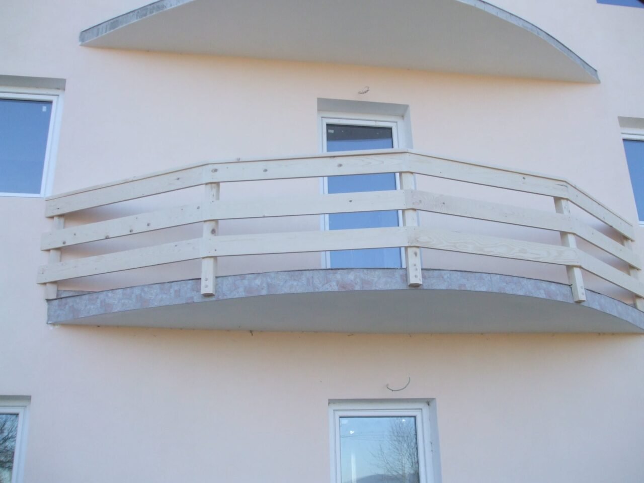 Balustradă curbă din lemn vopsit alb, la un balcon